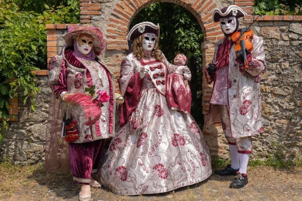 people-in-red-carnival-costume-16954889 A family in ornate Venetian costumes poses outdoors in Clisson, France.